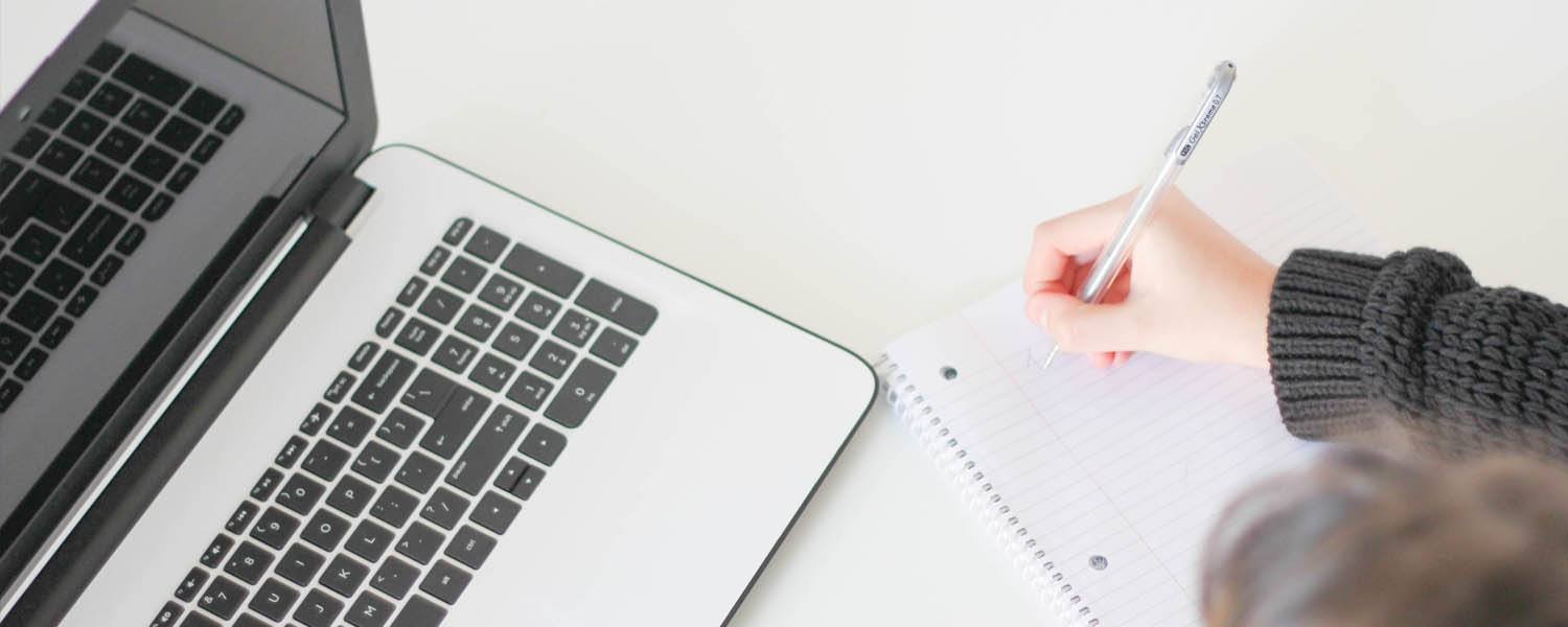 woman writing on a pen and paper